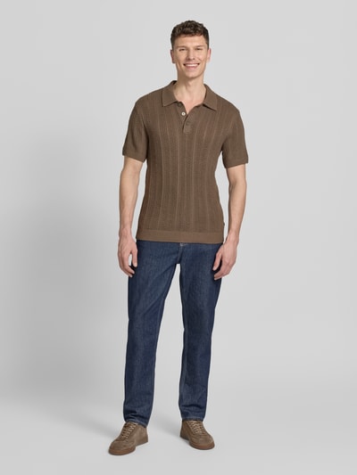 Männermodel trägt Slim Fit Poloshirt mit Knopfleiste von Jack & Jones Premium in Braun, Baumwoll-Mix, Polokragen, Ganzkörperansicht von vorne. Rückenlänge bei Größe M: 72 cm.