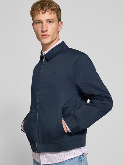 Männermodel trägt Regular Fit Jacke aus Baumwoll-Mix von REVIEW in Dunkelblau mit Umlegekragen und Logo-Stitching, Ganzkörperansicht von vorne. Rückenlänge 66 cm, Schulterbreite 49 cm, Brustweite 56 cm, Ärmellänge 64 cm.