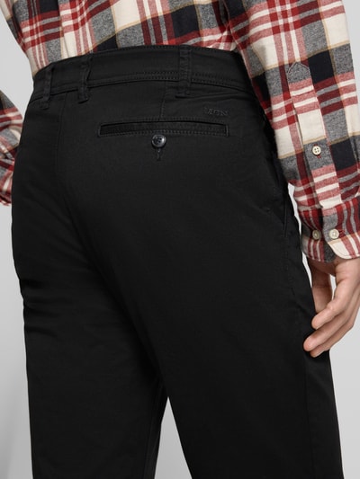 Männermodel trägt Straight Fit Chino mit Gesäßtaschen von MCNEAL in Schwarz, Baumwoll-Mix, Detailaufnahme Gesäßtasche, Nahaufnahme Rückansicht.