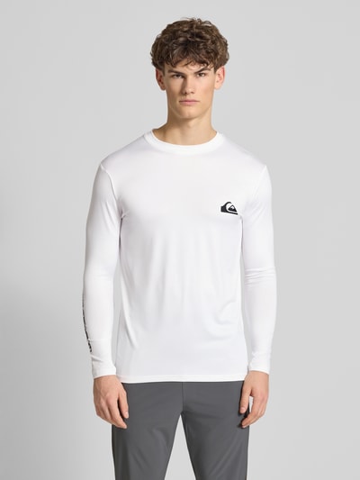 Männermodel trägt Langarmshirt mit Sonnenschutz Modell 'EVERYDAY' von Quiksilver, weiß, körpernah, Label-Print, Ganzkörperansicht von vorne.