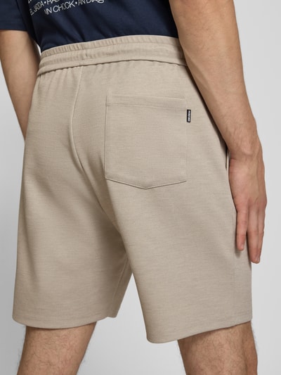 Mężczyznamodel nosi Straight Fit Shorts mit Viskose-Anteil von REVIEW, elastyczna mieszanka materiałów, tunel, szorty, odcień beżowy, Szerokość w rozmiarze M: 43 cm, Długość wewnętrzna nogawki w rozmiarze M: 19 cm, Ganzkörperansicht Rückansicht.