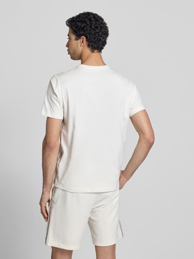 Männermodel trägt T-Shirt mit Logo und Rundhalsausschnitt von CHAMPION in Weiß, Reine Baumwolle, Regular-Fit, Rückenlänge Größe M 68 cm, Ganzkörperansicht Rückansicht.