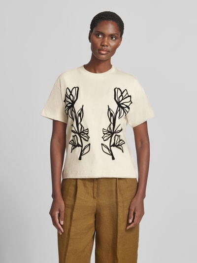 Frauenmodel trägt Regular Fit T-Shirt aus reiner Baumwolle von Jake*s Casual in Creme mit schwarzen Blumenlinien, glatter Stoff, Ganzkörperansicht von vorne.