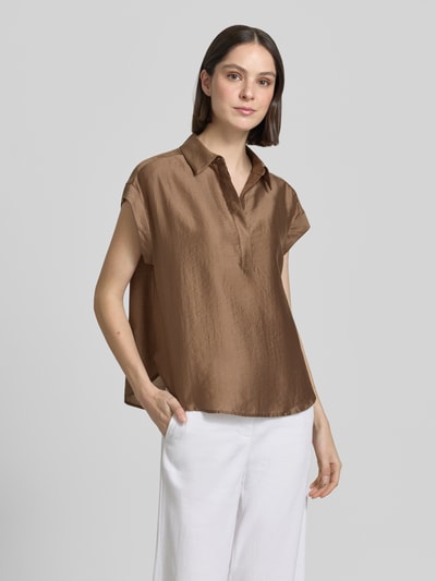 Frauenmodel trägt Regular Fit Bluse aus Lyocell-Mix Modell 'Zamin' von Someday, braun schimmernd, Hemdblusenkragen, Kappärmel, verdeckte Knopfleiste, Rückenlänge bei Größe 36: 62 cm, Ärmellänge: 12 cm, glatte Textur, Ganzkörperansicht von vorne.