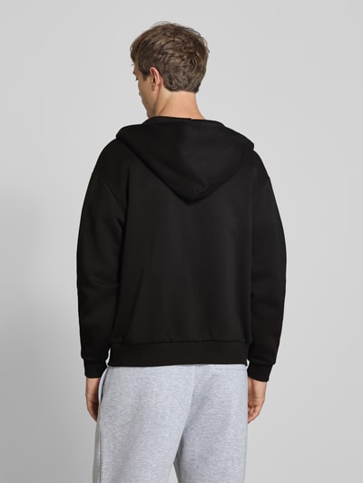 Männermodel trägt Relaxed Fit Sweatjacke aus Baumwoll-Mix mit Label-Detail von REVIEW, schwarze Farbe, Rückenansicht, Ganzkörperansicht Rückansicht.