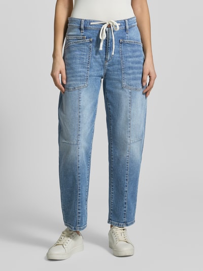 Frauenmodel trägt Straight Fit Jeans mit aufgesetzten Taschen Modell 'Ocean' von Cambio aus elastischem Baumwoll-Mix in mittlerem Blau, sichtbare Nähte, Bund mit Tunnelzug, Knopf- und Reißverschluss, Gesäßtaschen, glatte Textur, Ganzkörperansicht von vorne, Bundweite bei Größe 36: 42 cm, Innenbeinlänge: 72 cm.