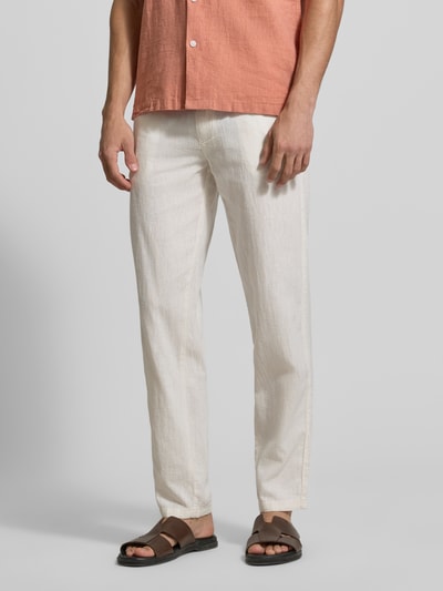 Męski model nosi Hose aus Leinen-Baumwoll-Mix mit elastischem Bund od Lindbergh, jasny beż, krój regular fit, kieszenie boczne, Szerokość w rozmiarze M: 40 cm, długość nogawki od wewnątrz w rozmiarze M: 79 cm, ujęcie całej sylwetki z przodu.