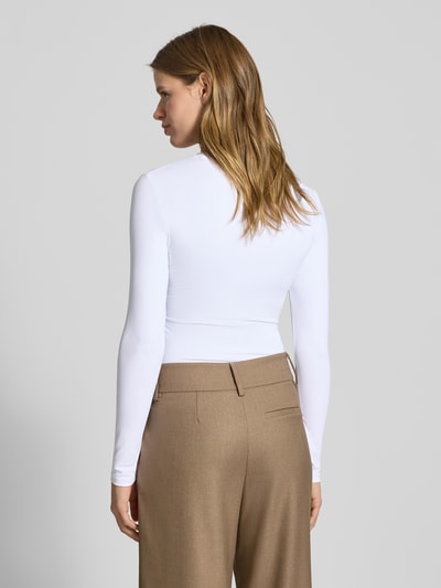 Modelka nosi Slim Fit Langarmshirt mit Rundhalsausschnitt Modell 'LULA' von Pieces, biały, jednolity, długa rękaw, stretchowa struktura, krój slim fit, widok całej sylwetki od tyłu.