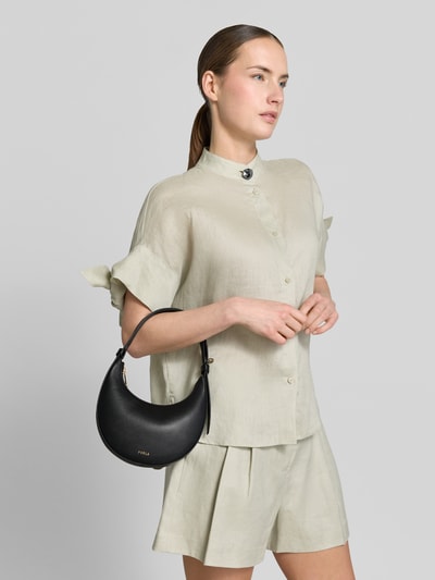 Frauenmodel trägt Handtasche aus Leder mit Label-Detail Modell 'DELIZIA MINI' von FURLA in Schwarz, feines Glattleder, Ganzkörperansicht von vorne. Hauptfach mit Reißverschluss, Tragehenkel, Maße 18x20x3 cm, Schulterriemen 34 cm.