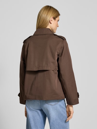 Modelka kobieca nosi Trenchcoat in kurzem Design mit Baumwoll-Anteil od Jake*s Casual, brąz, prosty krój, materiał z bawełną, długość tyłu 64 cm w rozm. 36, szerokość ramion 44 cm, szerokość w rozmiarze 51 cm, długość rękawa 60 cm, widok całej sylwetki z tyłu.