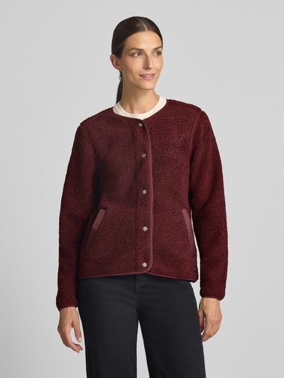 Frauenmodel trägt Regular Fit Jacke mit Strukturmuster Modell 'Selma' von Didriksons in Dunkelrot, Eingrifftaschen, Knopfleiste, Ganzkörperansicht von vorne. Rückenlänge 59 cm, Schulterbreite 36 cm, Brustweite 50 cm, Ärmellänge 65 cm.