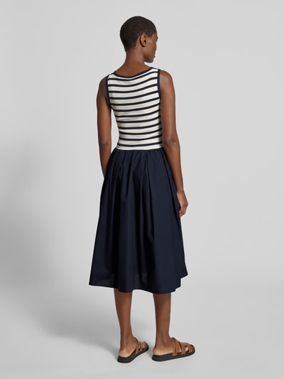 Frauenmodel trägt Midikleid mit Rundhalsausschnitt und Eingrifftasche von Gant, Baumwoll-Mix mit Modal-Anteil, A-Linie, Feinripp, Ganzkörperansicht Rückansicht.