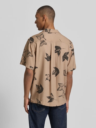 Männermodel trägt Regular Fit Freizeithemd aus reiner Viskose Modell 'TERRY' von SELECTED HOMME in Beige mit schwarzem Blattmuster, Ganzkörperansicht Rückansicht.