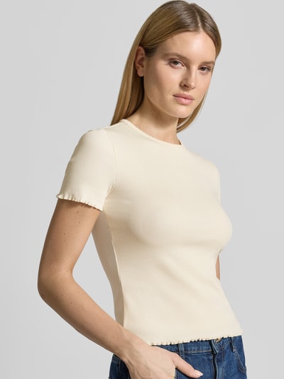 Modelka kobieca ma na sobie damski t-shirt z mieszanki bawełny z dodatkiem streczu od Jake*s Casual, drobne prążkowanie, dopasowany krój, okrągły dekolt, falisty brzeg, długość tyłu w rozmiarze S: 52 cm, T-shirt z Wellensaum od Jake*s Casual, jednolity kolor ecru, widok z przodu zbliżenie na górną część ciała.