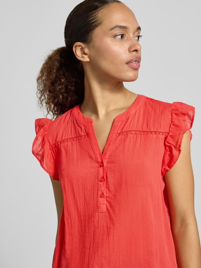Frauenmodel trägt Blusenshirt mit kurzer Knopfleiste Modell 'FABIANA' von Soyaconcept in Korallrot, Reine Baumwolle, Gerader-Schnitt, Serafino-Ausschnitt, Nahaufnahme Oberkörper.