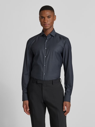 Männermodel trägt Slim Fit Businesshemd aus Baumwolle mit Kentkragen von OLYMP Level Five in dunklem Farbton, Knopfleiste, Ganzkörperansicht von vorne.