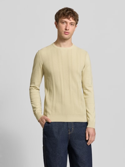Männermodel trägt Slim Fit Pullover in Strick-Optik Modell 'Baron' von Blend aus reiner Baumwolle, Rundhalsausschnitt, hellbeige Farbe, elastische Abschlüsse, Ganzkörperansicht von vorne.