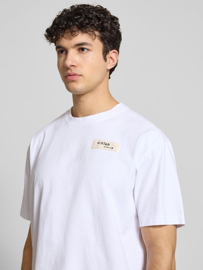 Männermodel trägt Relaxed Fit T-Shirt mit Label-Badge von G-Star Raw, puur katoen, ronde hals, heren T-shirt, ruglengte maat M 70 cm, Nahaufnahme Oberkörper.