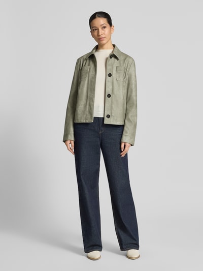 Frauenmodel trägt Regular Fit Jacke in Leder-Optik von Amber & June in hellem Grün, Umlegekragen, Brusttaschen, Knopfleiste, Jeans, Ganzkörperansicht von vorne. Rückenlänge 54 cm, Schulterbreite 42 cm, Brustweite 52 cm, Ärmellänge 63 cm bei Größe 36.