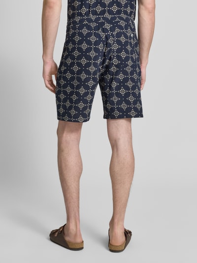 Männermodel trägt Relaxed Fit Stoffshorts aus einer katoen von s.Oliver RED LABEL, donkerblauw met wit patroon, Ganzkörperansicht Rückansicht.