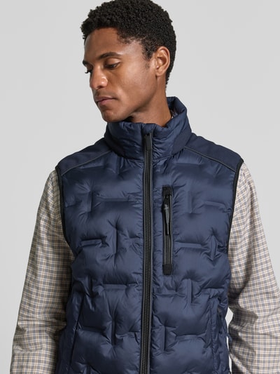 Männermodel trägt Regular Fit Outdoor-Weste mit reflektierenden Elementen von Tom Tailor in Dunkelblau, Nahaufnahme Oberkörper. Herren Outdoor-Weste von Tom Tailor.