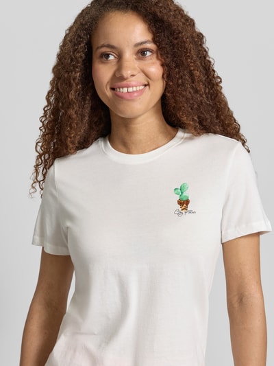 Frauenmodel trägt Slim Fit T-Shirt aus reiner Baumwolle Modell 'KITA' von Only, unifarben, Motiv-Print mit Pailletten, Rundhals, Jersey, Nahaufnahme Oberkörper.