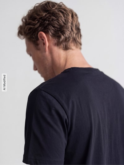 Männermodel trägt T-Shirt mit Rundhalsausschnitt von MCNEAL in Schwarz, reine Baumwolle, Slim Fit, Rückansicht, Nahaufnahme Oberkörper.