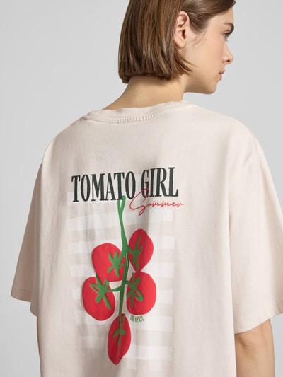Frauenmodel trägt Oversized T-Shirt mit Label-Stitching von OH APRIL in Reine Baumwolle, heller Farbton, Rückendruck, Rückenlänge 70 cm, Ganzkörperansicht Rückansicht.
