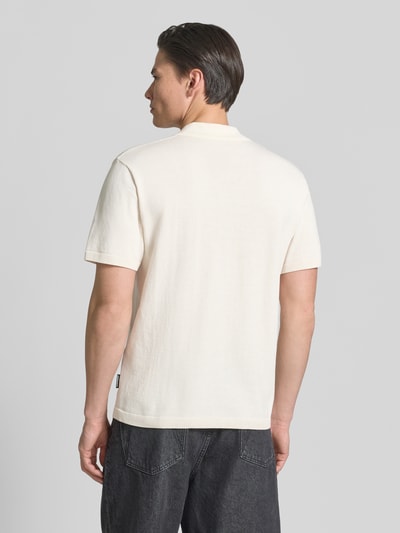 Männermodel trägt Relaxed Fit Poloshirt aus reiner Baumwolle von Armedangels, Optik: Unifarben, Passform: Relaxed-Fit, Label-Patch, Kragenform: Polokragen, V-Ausschnitt, Ärmelform: Kurzarm, Ärmelabschluss: Gerippt, Materialverarbeitung: Feinstrick, Farbe Creme, Ganzkörperansicht Rückansicht.