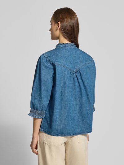 Vrouwenmodel draagt Regular Fit Jeansbluse aus reiner Baumwolle Modell 'RAYA' van Only, effen blauw denim met rüschenkraag en V-hals, rugpasse en elastische 3/4-mouwen, materiaal denim katoen, volledig zicht van achteren.