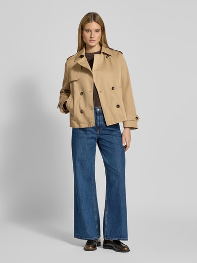 Frauenmodel trägt Trenchcoat in kurzem Design mit Baumwoll-Anteil von Jake*s Casual in Beige, gerade Passform, Umlegekragen, Ganzkörperansicht von vorne.