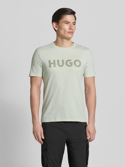Männermodel trägt Relaxed Fit T-Shirt aus reiner Baumwolle Modell 'DULIVIO' von HUGO, Optik: Unifarben, Label-Schriftzug, Kurzarm, Nahaufnahme Oberkörper.
