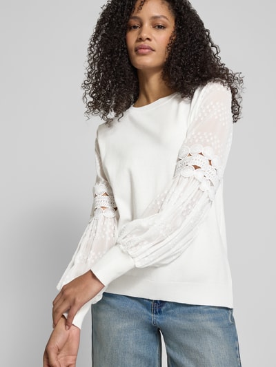 Frauenmodel trägt Strickpullover aus Viskose mit semitransparenten Ärmeln von Apricot in Cremeweiß, Regular Fit, Jeans kombiniert, Nahaufnahme Oberkörper.