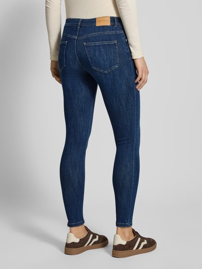 Frauenmodel trägt Slim Fit Jeans im 5-Pocket-Design von Review aus elastischem Baumwoll-Mix in Dunkelblau, Ganzkörperansicht Rückansicht.