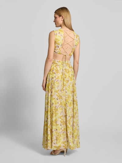 Frauenmodel trägt Regular Fit Maxikleid mit floralem Allover-Print von ADLYSH, gelb mit Falten-Optik, Rüschenbesatz, Cut-Outs, Schnürverschluss, ärmelloses Design, V-Ausschnitt, Ganzkörperansicht Rückansicht.
