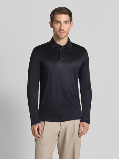 Männermodel trägt Slim Fit Poloshirt aus Lyocell-Mix von Emporio Armani in Dunkelblau mit Polokragen, Ganzkörperansicht von vorne.
