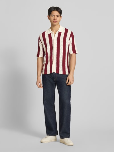 Männermodel trägt Regular Fit Poloshirt mit Knopfleiste Modell 'TYLER' von Jack & Jones, Baumwoll-Mix, gestreift, Ganzkörperansicht von vorne. Rückenlänge bei Größe M: 70 cm, Schulterbreite: 62 cm, Ärmellänge: 30 cm, 1/2-Arm.