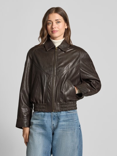 Frauenmodel trägt dunkelbraune Lederjacke mit Reißverschluss Modell 'PATNEY' von DRYKORN, Umlegekragen, Regular Fit, Ganzkörperansicht von vorne.