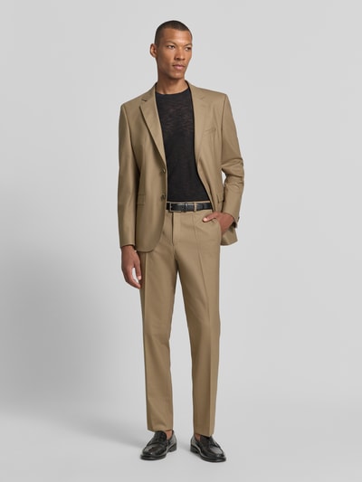 Männermodel trägt Super Slim Fit Anzughose aus Woll-Mix Modell 'Hesten253X' von HUGO, beige Farbe, glatte Textur, Ganzkörperansicht von vorne, Herren Anzughose von HUGO.