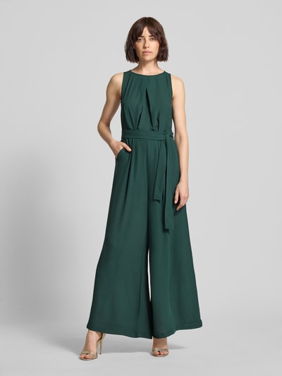 Frauenmodel trägt Jumpsuit mit Bindegürtel und Eingrifftaschen von Zero in dunklem Grün, Taillierter Schnitt, Rundhalsausschnitt, Ganzkörperansicht von vorne, Rückenlänge 143 cm, Brustweite 30 cm, Gesamtlänge 143 cm, Innenbeinlänge 77 cm, Größe 36.