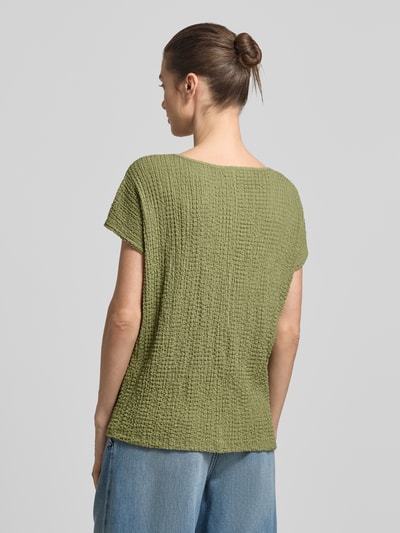 Männermodel trägt Relaxed Fit T-Shirt mit Strukturmuster von s.Oliver RED LABEL, zielony kolor, teksturowany crinkle materiał, unifarbene optyka, krótkie rękawy, krój relaxed fit, widok całej sylwetki z tyłu.