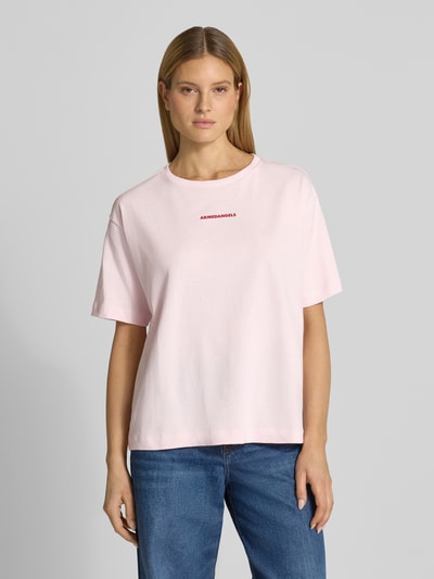 Frauenmodel trägt Oversized T-Shirt aus reiner Baumwolle Modell 'GIANNAA CHAANGE' von Armedangels, rosa, Rundhals, Label Print, Ganzkörperansicht von vorne.