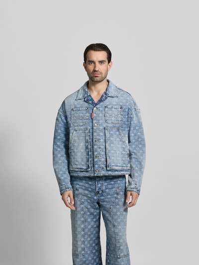 Männermodel trägt Jeansjacke aus reiner Baumwolle von Dsquared2 in Regular-Fit, Allover-Label-Stitchings, Ganzkörperansicht von vorne.