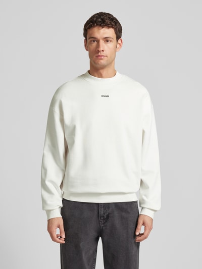 Männermodel trägt Regular Fit Sweatshirt aus reiner Baumwolle Modell 'DAPOCREW' von HUGO, unifarben, Rundhals, Ganzkörperansicht von vorne.