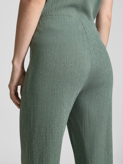 Kobiece modelka nosi Hose mit Strukturmuster und elastischem Bund od Christian Berg Woman, materiał z domieszką wiskozy, krój relaxed fit, elastyczny pas, strukturalna powierzchnia, kolor zielony, zbliżenie tylnej części, detailaufnahme.