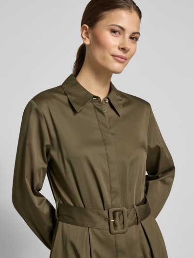 Vrouwenmodel draagt Regular Fit Midikleid mit Umlegekragen van comma in olijfgroen, elastische katoenmix, tailleband, lange mouwen, doorlopende knoopsluiting, getailleerde pasvorm, detailopname bovenlichaam.