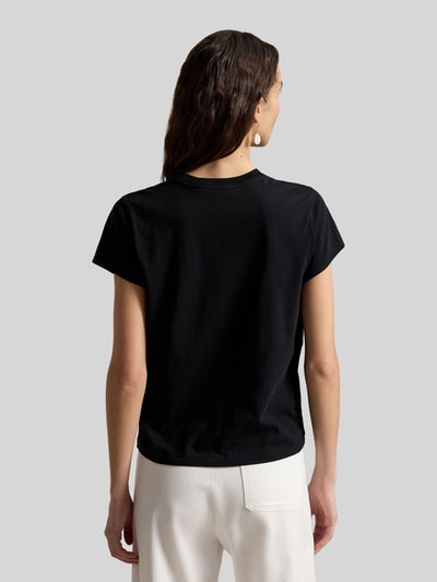 Frauenmodel trägt Regular Fit T-Shirt aus reiner Baumwolle von Polo Ralph Lauren in Schwarz, kombiniert mit weißer Hose, Ganzkörperansicht Rückansicht. Damen T-Shirt von Polo Ralph Lauren