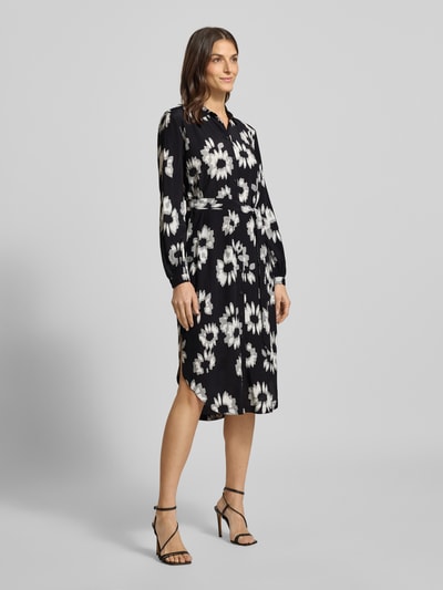 Frauenmodel trägt Midikleid mit Bindegürtel von Esprit, reine Viskose, gerader Schnitt, Umlegekragen, floraler Allover-Print, durchgehende Knopfleiste, Bindegürtel, dunkle Grundfarbe mit weißen und grauen Blumen, Ganzkörperansicht von vorne.