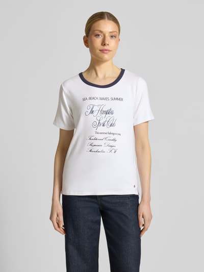 Frauenmodel trägt Damen T-Shirt aus Viskose-Mix Modell 'Hamptons Spirit' von monari in Weiß mit Rundhalsausschnitt, Gerader-Schnitt, 1/2-Arm; Rückenlänge bei Größe 36: 51 cm, Ganzkörperansicht von vorne.
