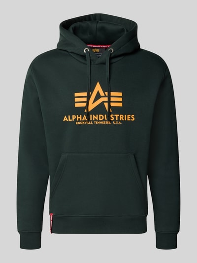 Produktfoto, Regular Fit Hoodie aus Baumwoll-Mix mit Logo-Print von Alpha Industries in Dunkelgrün, orangefarbener Aufdruck, elastische Abschlüsse, Kapuze mit Tunnelzug, langärmlig, Label am Saum